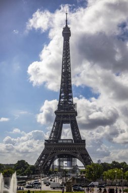 Eiffel Tower of Paris from the Trocadero Gardens and with the fluffy clouds beside the Seine River this monument is the iconic symbol of Paris and France.