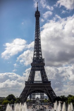 The Eiffel Tower in Paris under a beautiful sky and with the fields of Mars of the French capital in the background and next to the Seine River, this monument is the iconic symbol of France.