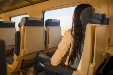 Trenle seyahat eden güzel bir hippi. Avrupa 'da rahat bir tren koltuğunda oturuyor. Turist seyahat kavramı.