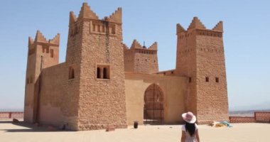 Orta Atlas ve Tadla düzlükleri arasında yer alan Beni Mellal şehrinde tarihi bir anıt olan Beni Mellal Kasbah 'ına yaklaşan genç turist kadın..