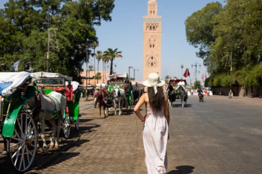 Marakeş 'in merkezi meydanı olan Jamaa el Fna Meydanı' nda, Medine 'nin en önemli yeri olan ve Fas' ın Marakeş kentindeki Koutoubia Camii 'nde bulunan at arabalarındaki turist kadınlar..
