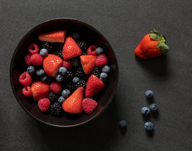 Çilek, böğürtlen ve böğürtlen siyah bir kasede.