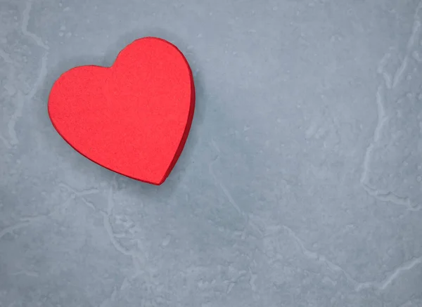 Açık gri arka planda kırmızı kalp yukarıdan hiç kimse tarafından çekilmez.
