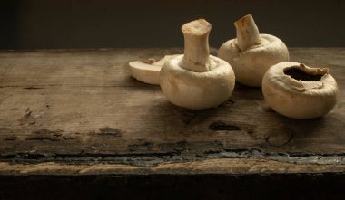 Kırsal ahşap bir masada üç mantarın hareketsiz hayatını kapat.