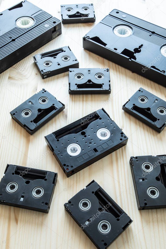 a selection of old retro style black video and music cassettes shot from above obsolete technology