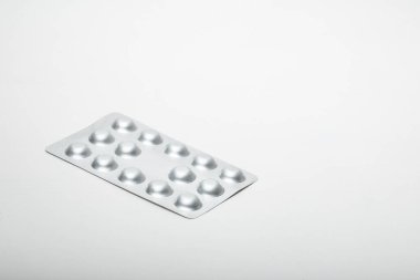 Beyaz arka planda folyo tablet şişirme ambalajını kapatın. Kimse yok.