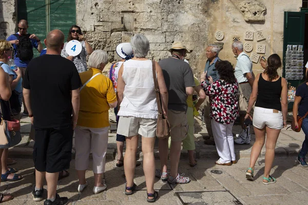 Bari Matera İtalya-23 Eylül 2015 tur rehberi Matera sokaklarında turistlere ilgi yerlerini gösteriyor