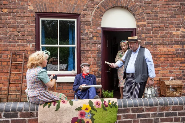 Dudley, Batı Midlands Birleşik Krallığı 16 Temmuz 2016 Sütçüsü 1940 'ların sokak sahnesinde bir aileye süt dağıtıyor