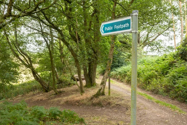 green public Footpath Sign against a woodland backdrop