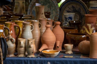 Ceramic clay terracotta jug, pot, vase, kitchen souvenirs on shelf at street handicraft pottery shop. Old earthen terracotta jug, pot, clay jar pattern in store. Clay brown various ceramic pot & jugs