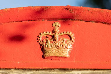 High Halden, Kent, Birleşik Krallık, 21 Ağustos 2022. Geleneksel İngiliz kırmızı telefon kulübesinin tepesinde altın boyalı taç sergileniyor.