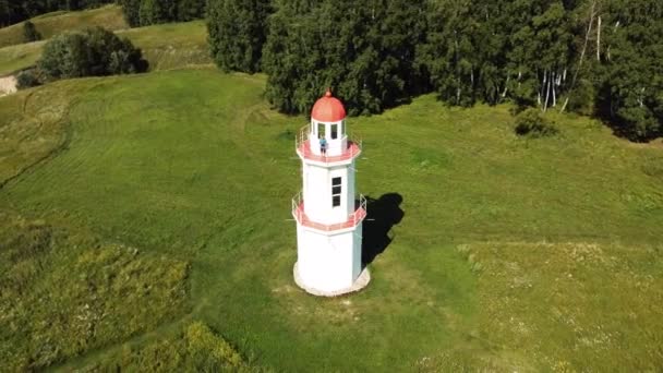 Een Man Zwaait Met Zijn Hand Terwijl Hij Een Vuurtoren — Stockvideo