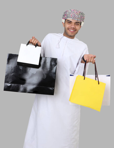 Omani man holding shopping bags
