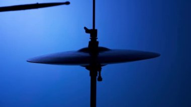 Davulcunun Silueti Mavi Arkaplanda Çubuklarla Yüksek Şapka Çalıyor