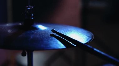 Davulcu sopalarla Hi-Hat zillerinde çalıyor