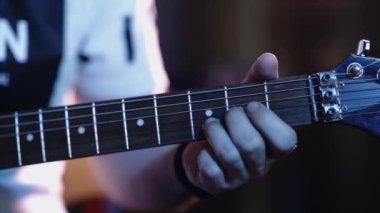 Elektro gitarda akorlar çalan müzisyen