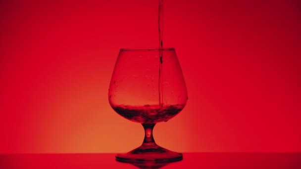 Ρίχνει Κονιάκ Ένα Ποτήρι Στο Κόκκινο Φόντο Σιλουέτα — Αρχείο Βίντεο