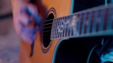 Gitar penalı akustik gitarda ritim çalan müzisyen.