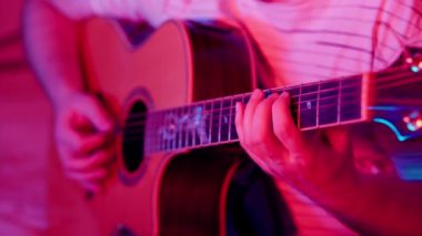 Adam akustik gitar çalıyor.