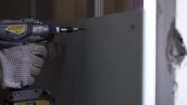 İşçi alçı levhayı metal profile vidaladı