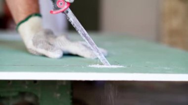 El testeresiyle Alçı Tahtayı Kesen İşçi