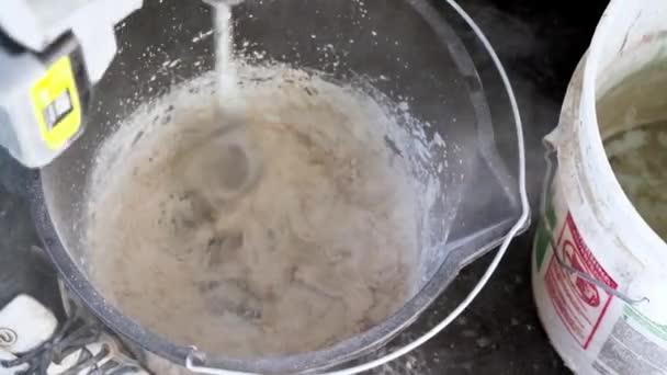 用电动搅拌机在桶内搅拌砂浆填料混合物 — 图库视频影像