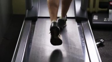Spor salonunda koşu bandında koşan bir adam