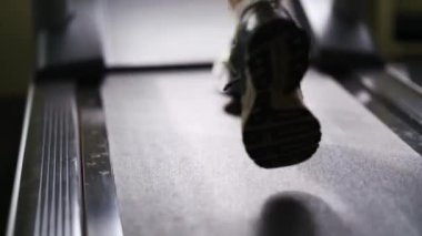 Spor salonunda koşu bandında koşan bir adam