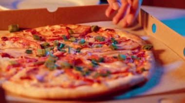 İnsan eli pizza kutusundan bir dilim et aldı.