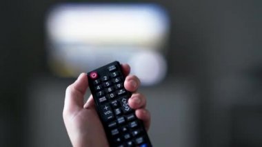 Hand Holding TV Remote Control And Turns Off TV