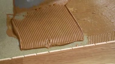 İşçi, malayla betona parke yapıştırıcısı uygular