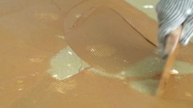 Beton zemine Spatula ile parke yapıştırıcısı sürülüyor