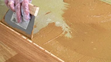 İşçi, malayla betona parke yapıştırıcısı uygular
