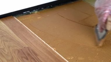 Beton zemine Spatula ile parke yapıştırıcısı sürülüyor