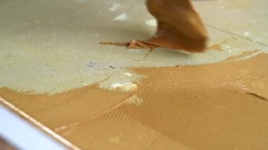Beton zemine Spatula ile parke yapıştırıcısı sürülüyor