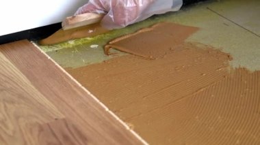 Beton zemine Spatula ile parke yapıştırıcısı sürülüyor