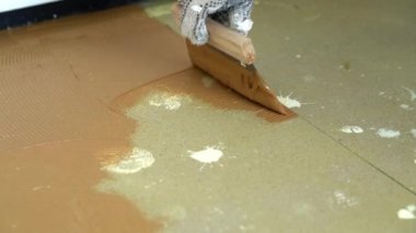 Beton zemine Spatula ile parke yapıştırıcısı sürülüyor