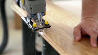 Worker Cuts Parquet Floor Board With Jigsaw