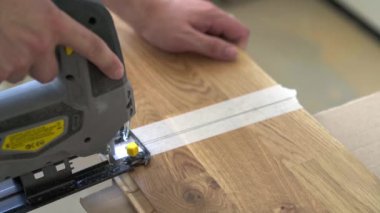 Worker Cuts Parquet Floor Board With Jigsaw
