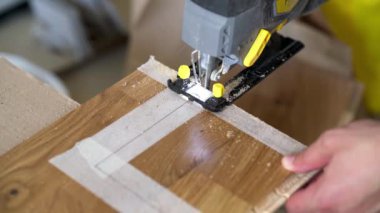 İşçi, parke döşeme tahtasını yapbozla kesti