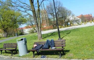 Polonya, Wroclaw, Xawery Dunikowski Bulvarı, bankta uyuyan bir adam