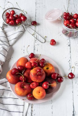 Meyveler tabakta. Peçeteli beyaz ahşap masa.