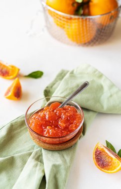 Kırmızı portakallar cam kasede, meyveler ve peçeteyle reçel.. 