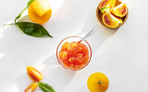 Red oranges jam in glass bowl with fruits