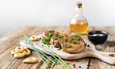 Baharatlı Seitan kazıkları, zeytinyağı, taze pırasa, kesme tahtasında tarallucci