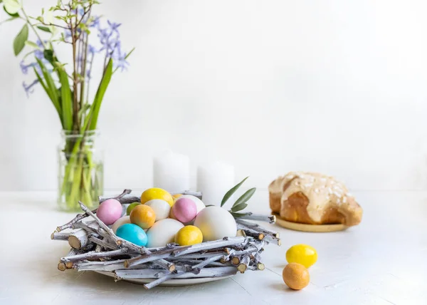 Composition de vacances pour Pâques. Nid avec couleur et œufs blancs, bougies, jacinthes et colomba — Photo