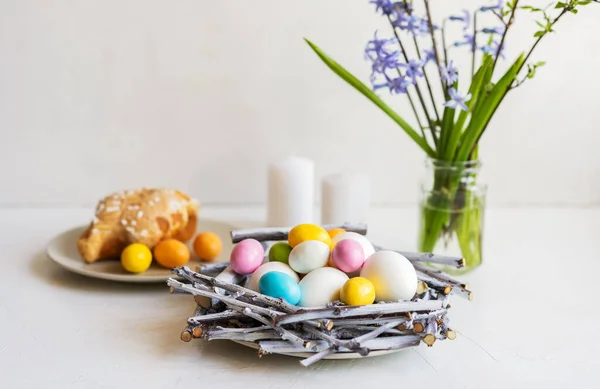 Composition de vacances pour Pâques. Nid avec couleur et œufs blancs, bougies, jacinthes et colomba — Photo