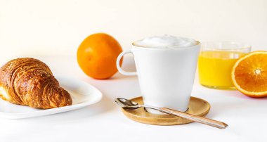 Kahve, portakal suyu ve kruvasanla kahvaltı konsepti.