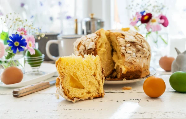 Пасхальная концепция с итальянским пасхальным тортом Colomba, цветные яйца, весенние цветы и кролики — стоковое фото