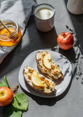 Kır peyniri, bal, elma ve fındıklı ekmek dilimleri. Kahvaltı konsepti
